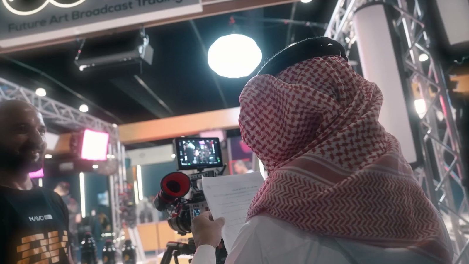 فريق تصوير يتابع شاشة المراقبة بين الأجنحة